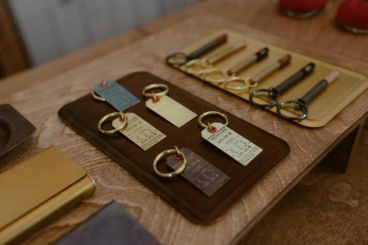 Porte-clés et stylos en laiton Picus sur un plateau