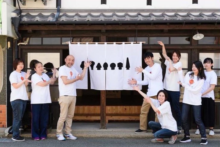 L’équipe de Shiraki Kougei devant l’atelier, sous le noren aux cinq silhouettes de Torchin