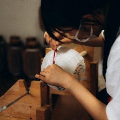 Artisane montant une lanterne dans l’atelier de Yame