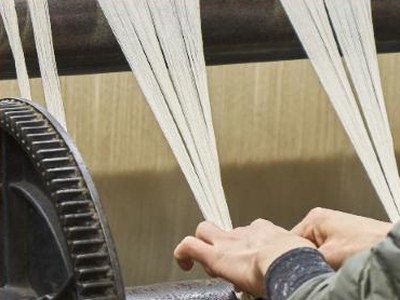 Mains guidant les fils de chaîne