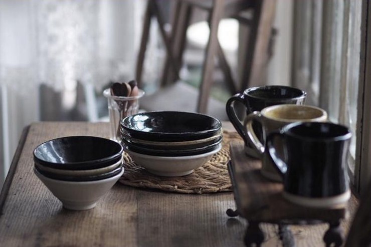Bols et mugs de la collection Heüge sur une table en bois