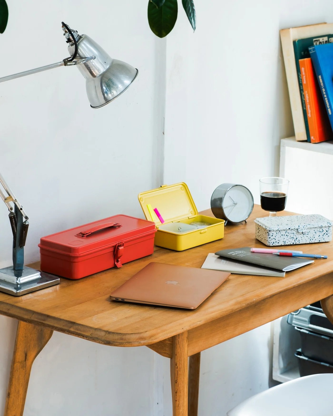 Bureau en bois avec boîtes Toyo Steel rouge et jaune, lampe, carnets et stylos