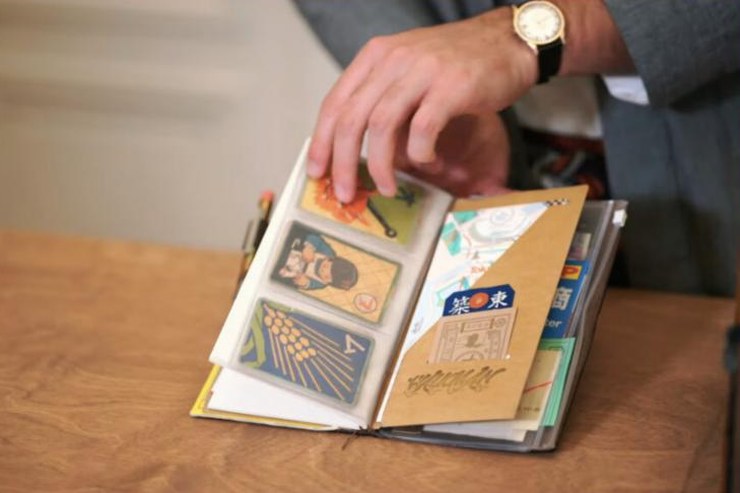 TRAVELER'S notebook ouvert, rempli de cartes et de souvenirs