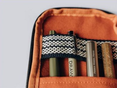 Intérieur orange de la pochette, avec ses stylos