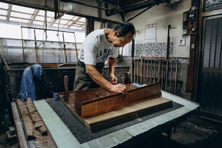 Artisan papetier de Yame formant une feuille de washi au tamis de bambou